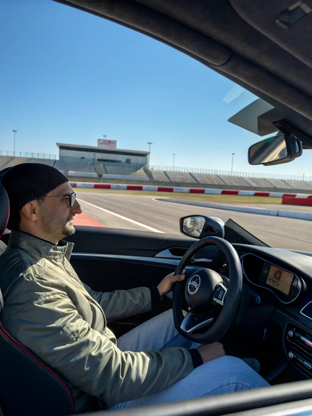 A driver receiving instruction from a professional coach during a NOAH RACING CONCEPT track day event, emphasizing the skill development and safety training provided.