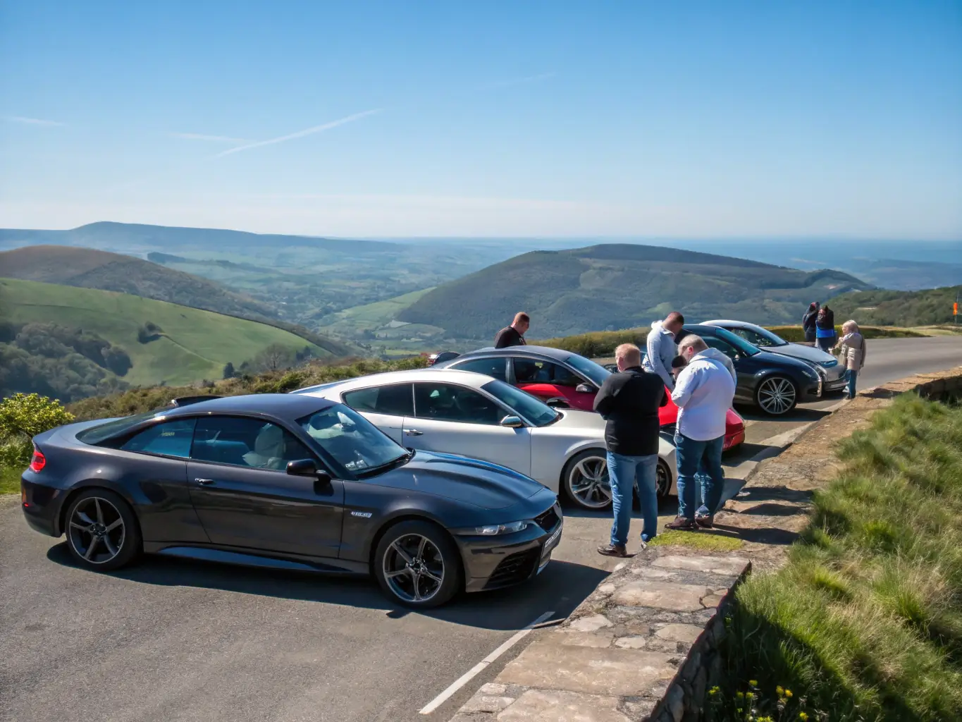 A group of classic cars parked at a scenic overlook during a NOAH RACING CONCEPT leisure outing, emphasizing the social and recreational aspects of the club.
